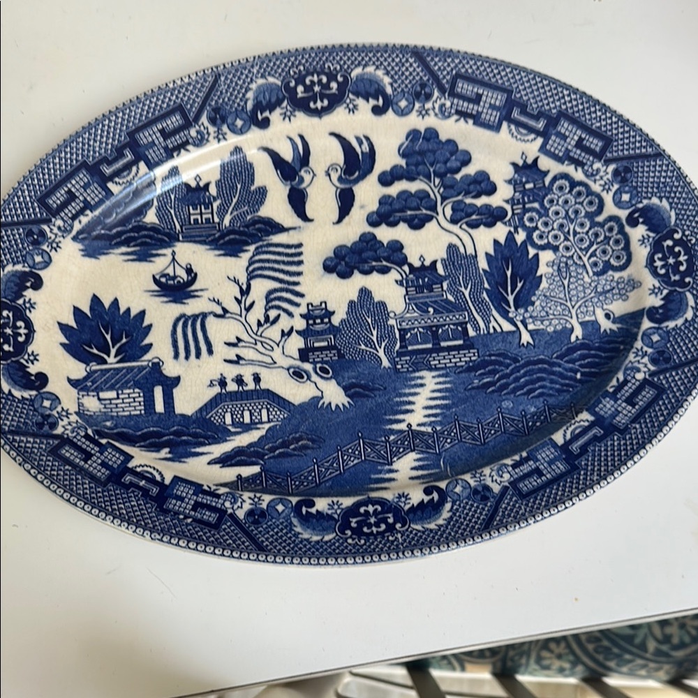 Blue and White Ceramic Plate with Intricate Willow Pattern